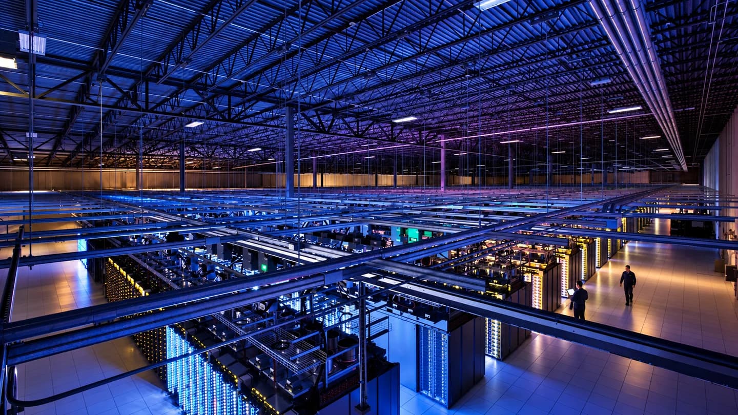 Illustrative data hall showing computing infrastructure and technicians working in an aisle.